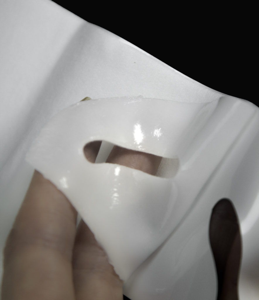 Peel the collagen gel layer away from the paper backing to apply the mask to the face