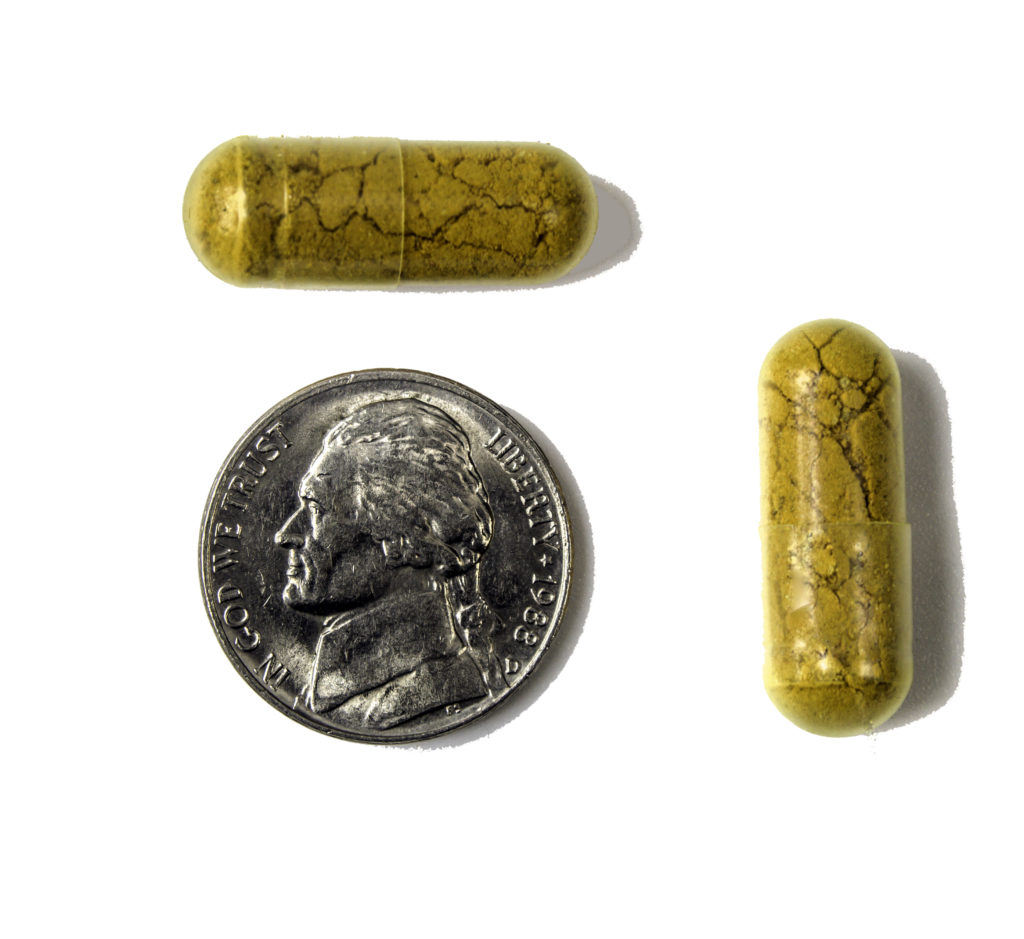 Capsules shown with a nickel for scale